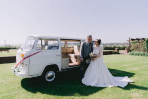 Bride and Groom with wedding car