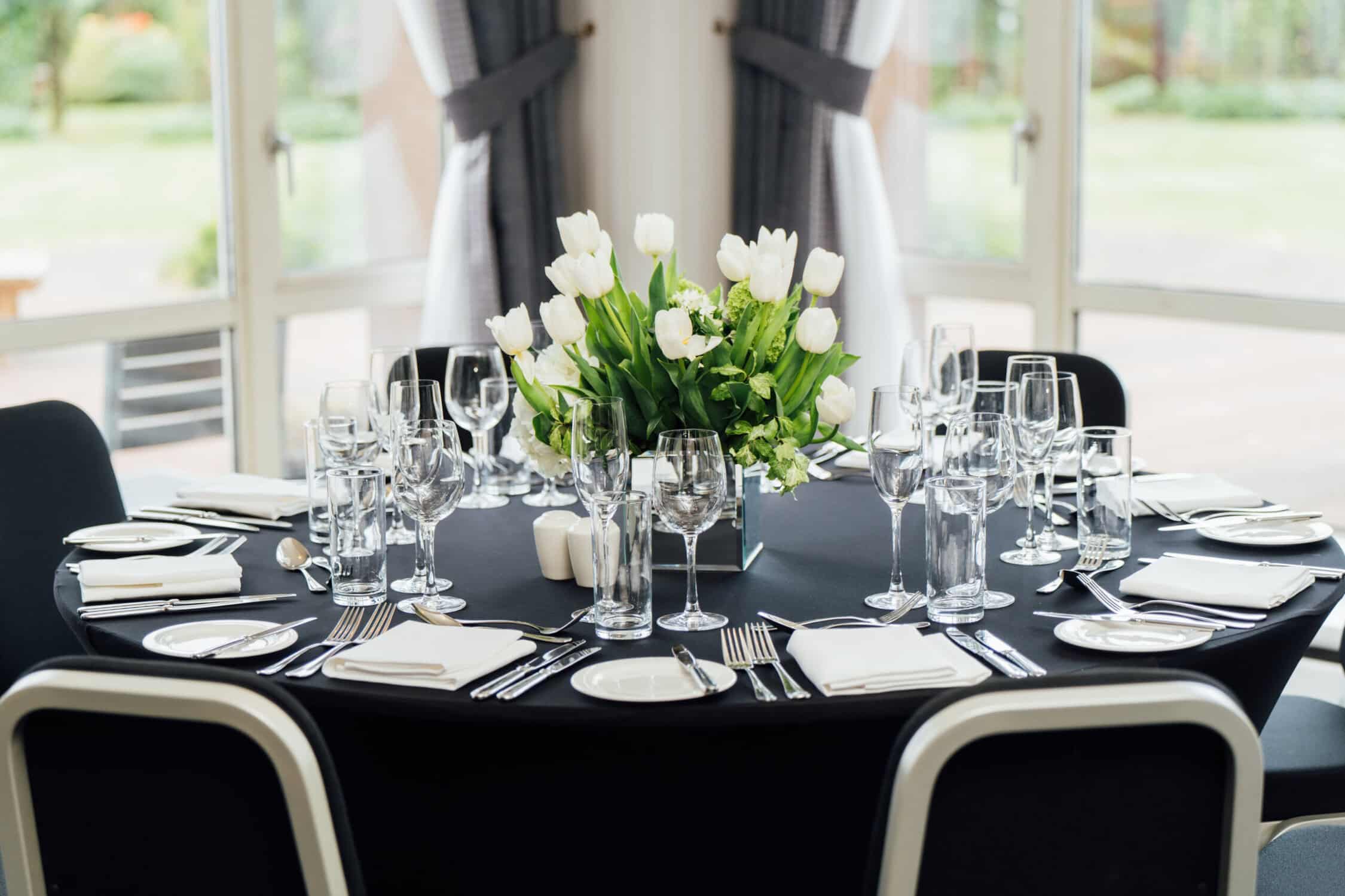 dining table set with black table cloth, glassware and cutlery