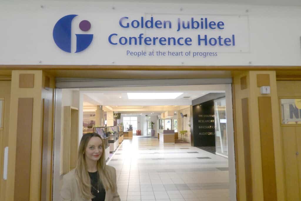 Michelle standing in front of Golden Jubilee Conference Hotel logo