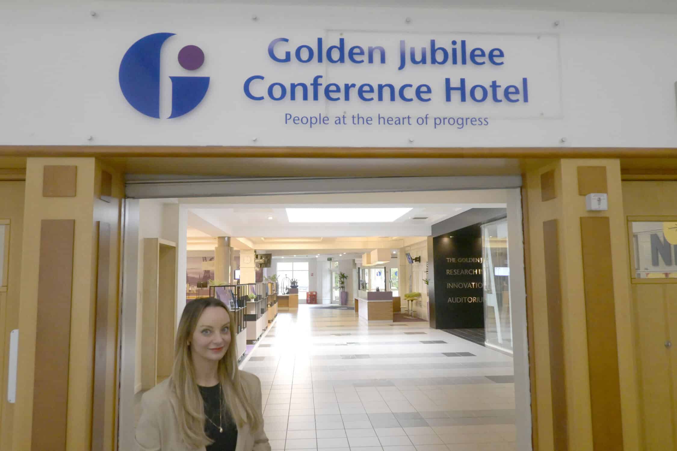 Michelle standing in front of Golden Jubilee Conference Hotel logo
